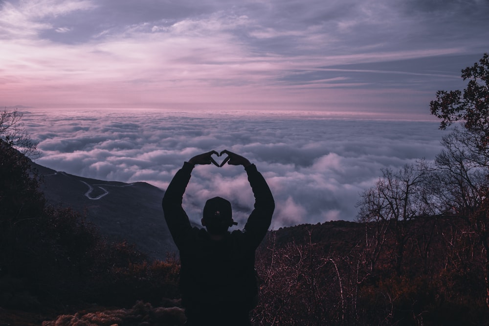 silhouette of man holding camera during sunset