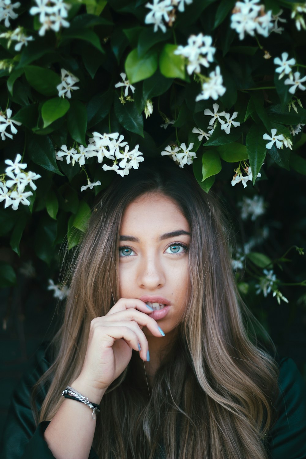 woman in black shirt standing beside white flowers