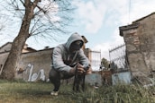 man in gray hoodie and black pants holding black and white labeled bottle