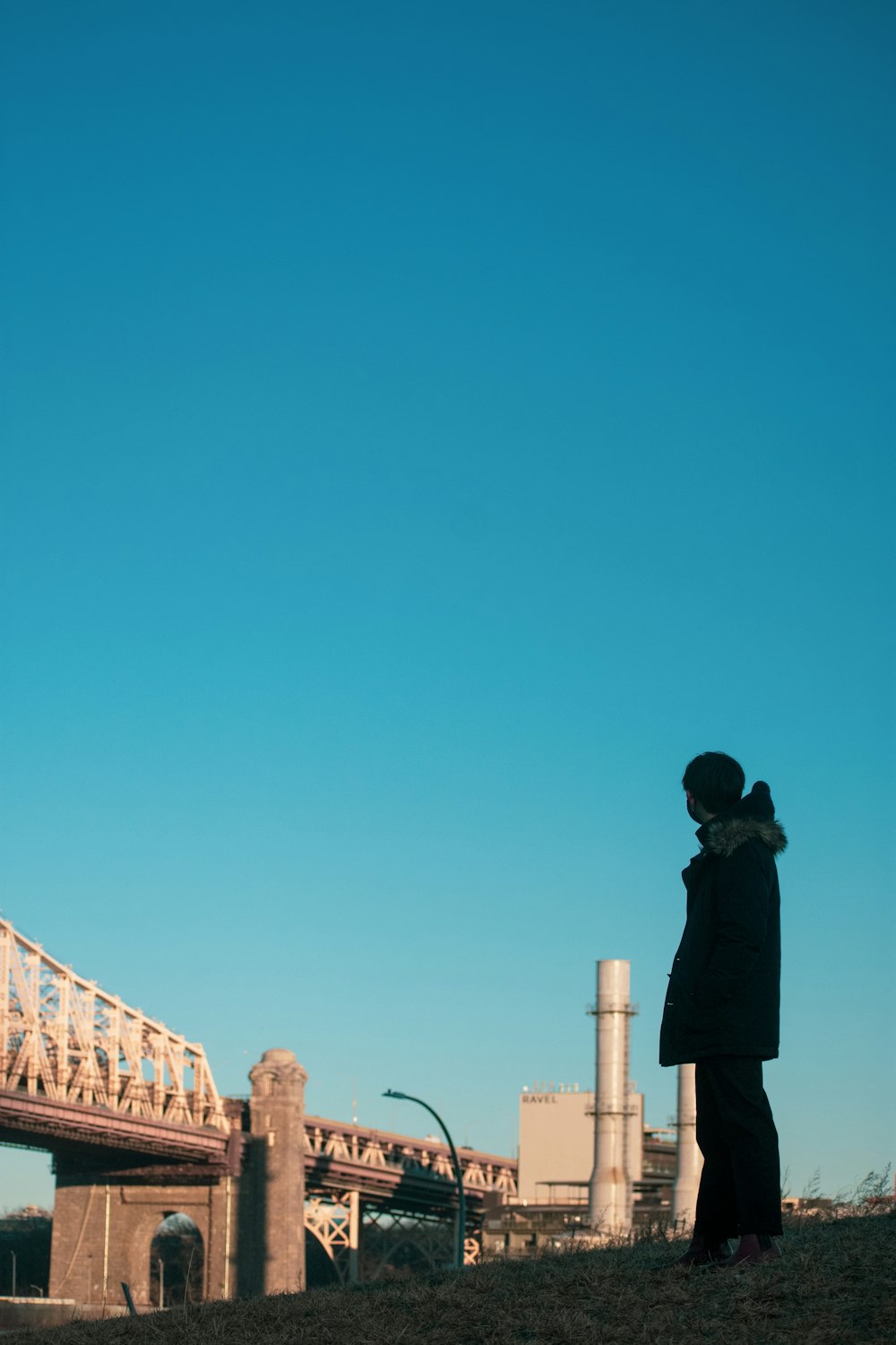 man in black jacket standing on brown wooden dock during daytime