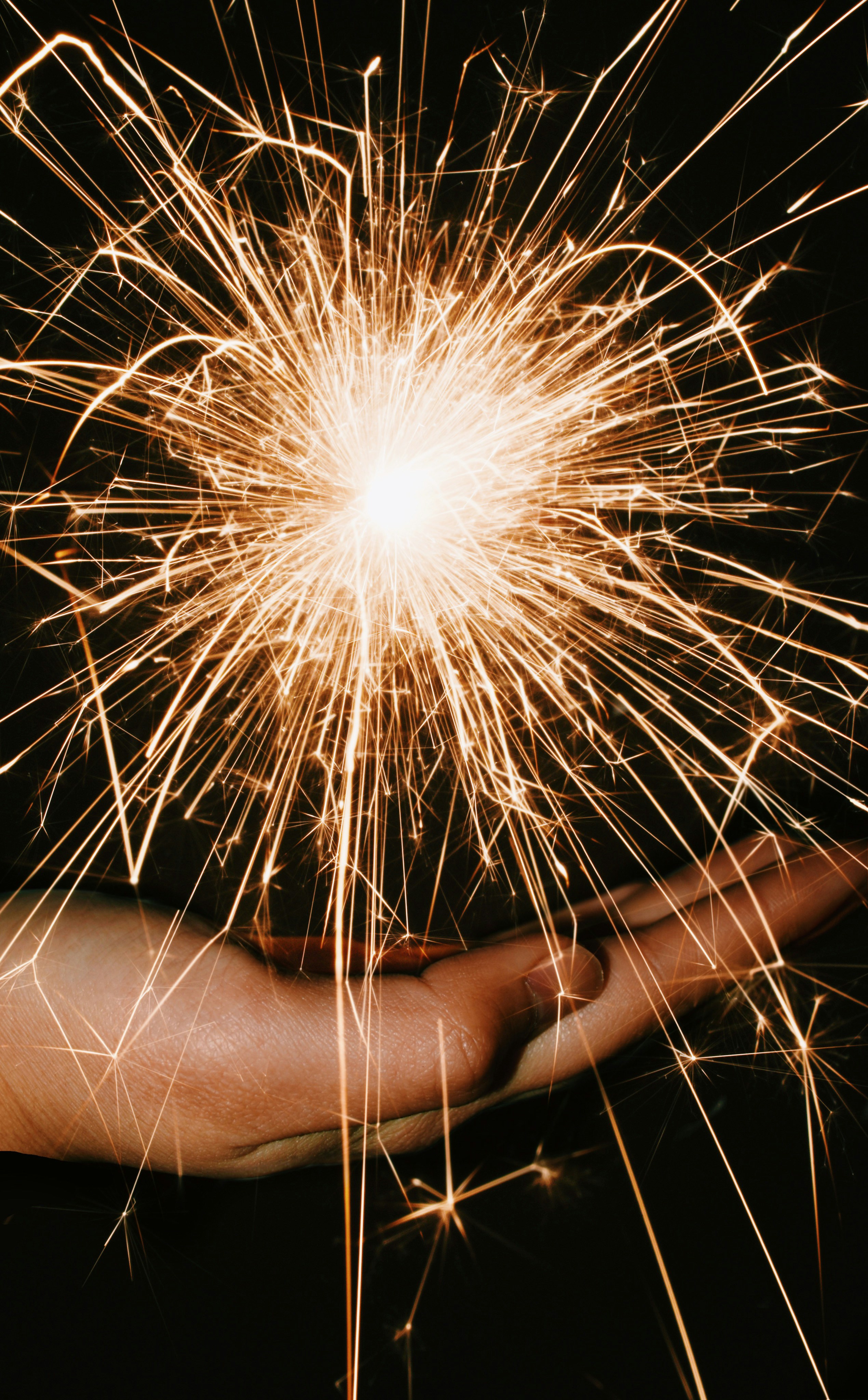 person holding sparkler during nighttime