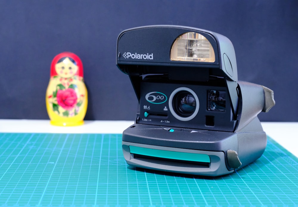 black polaroid camera on blue and white table