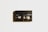 A vintage black Sony MP90 8mm video cassette is centered against a light background. It has visible spools through a transparent window and displays the text 'Sony', 'MP90', and 'PAL 8'. A subtle shadow casts to the left, adding depth.