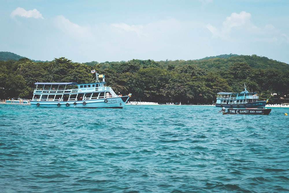 white and blue boat on body of water during daytime