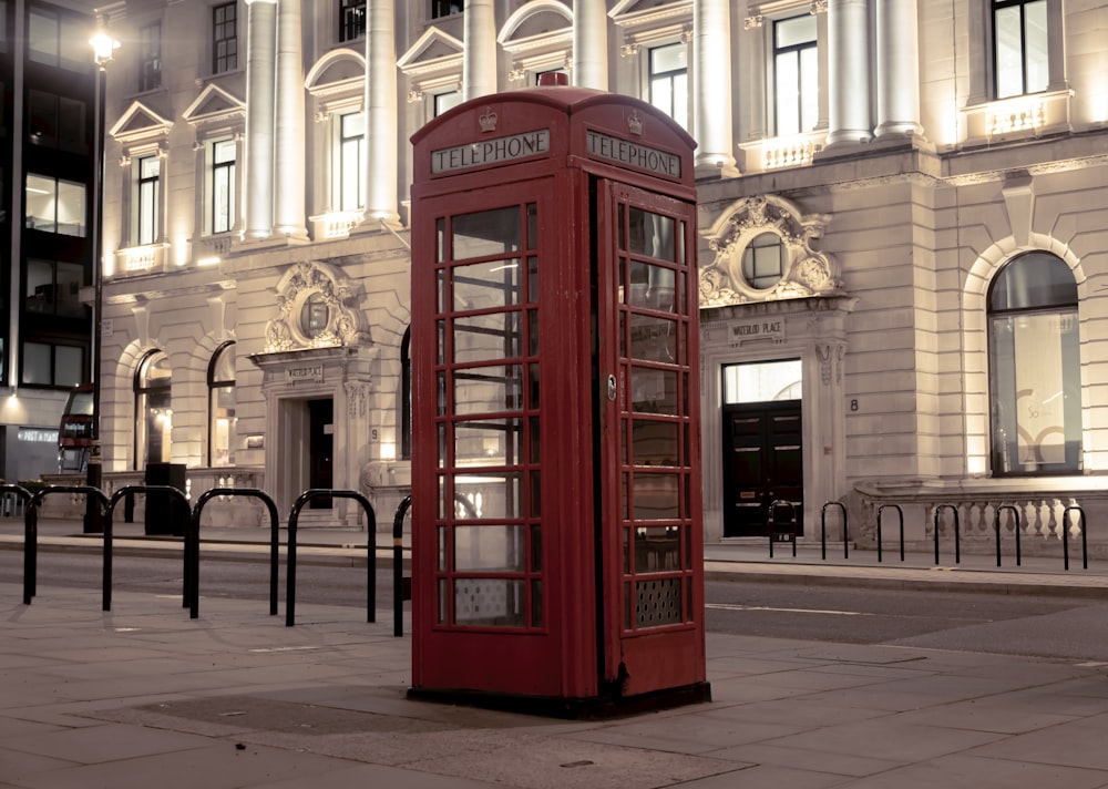 red telephone booth near building during daytime