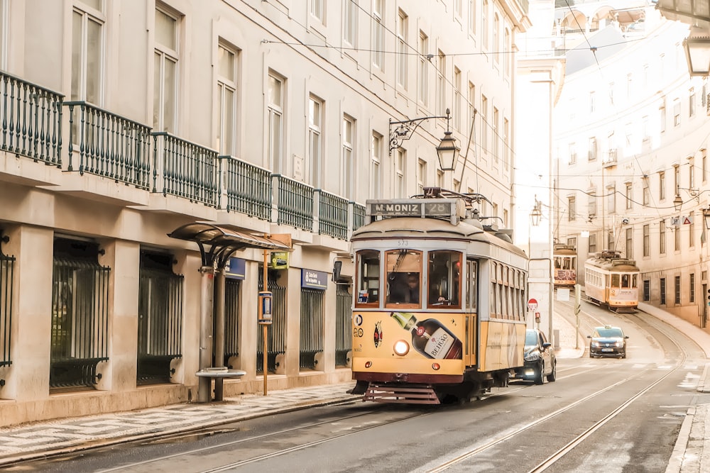 tranvía amarillo y blanco en la carretera cerca del edificio durante el día