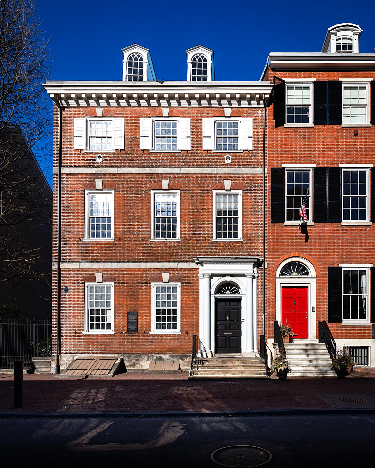 Historic brick townhouses in Philadelphia with white trim and black shutters