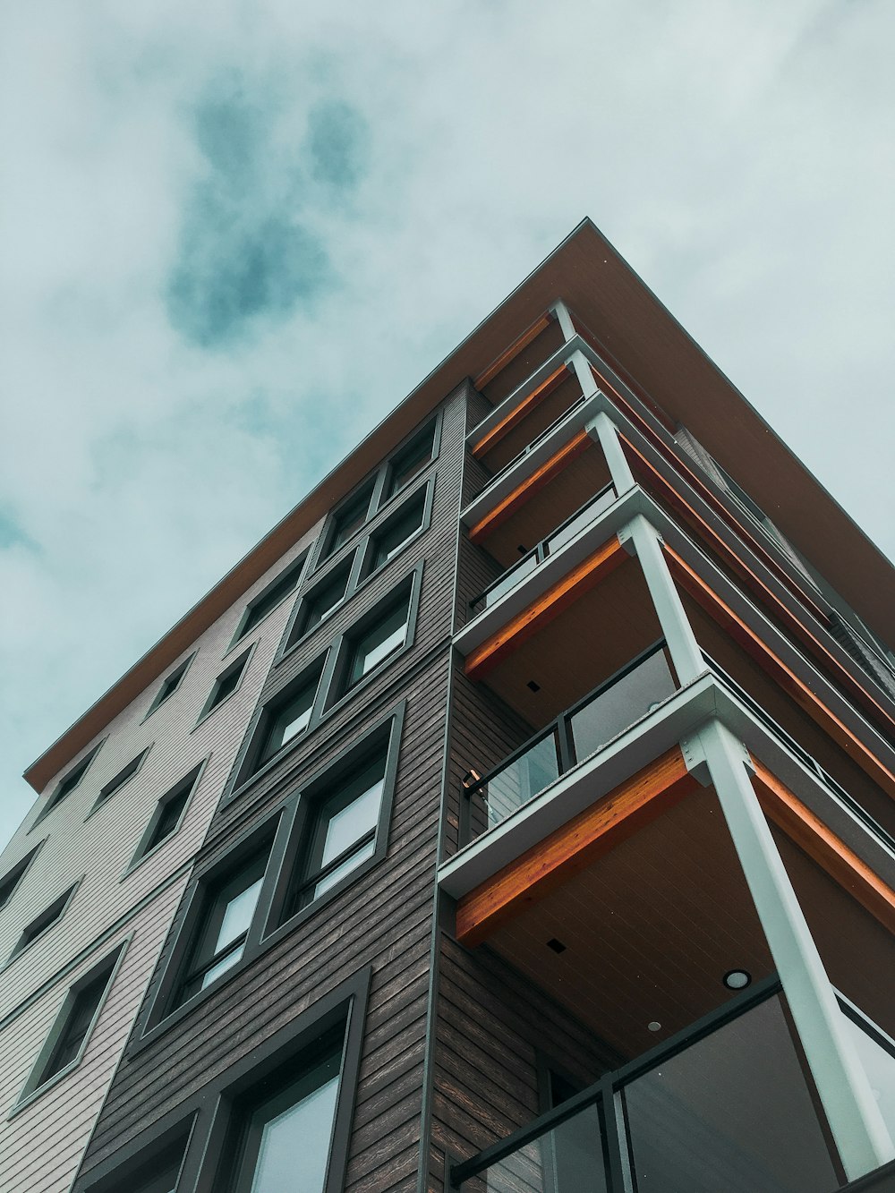 brown and white concrete building under white clouds during daytime