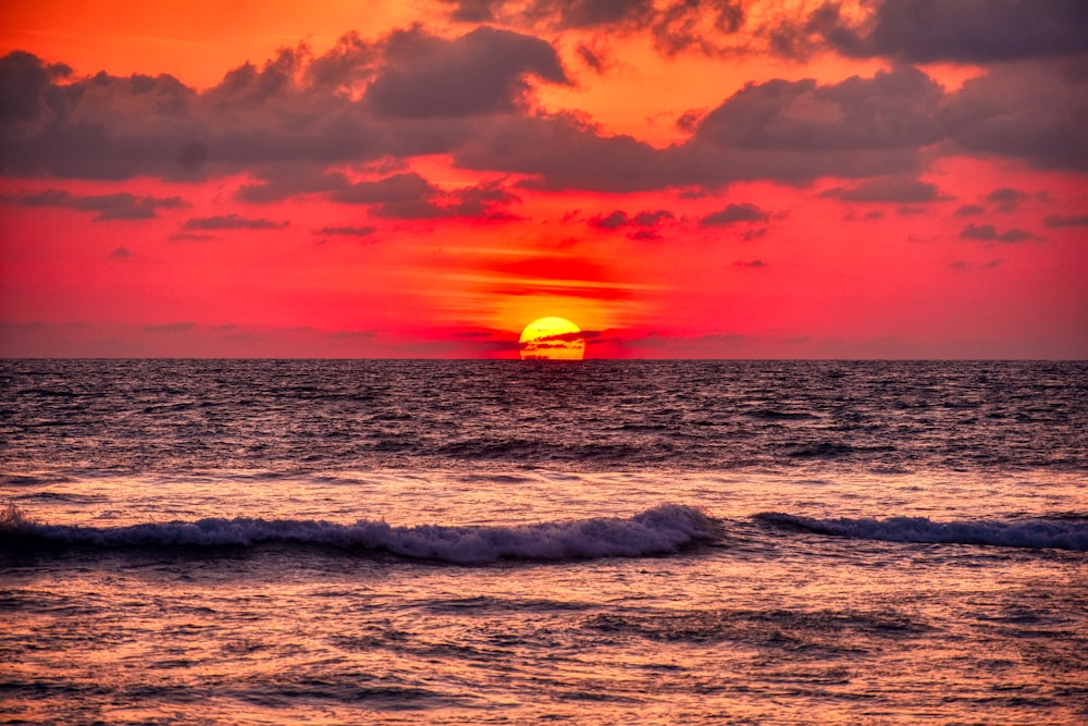 Meereswellen stürzen während des Sonnenuntergangs an Land