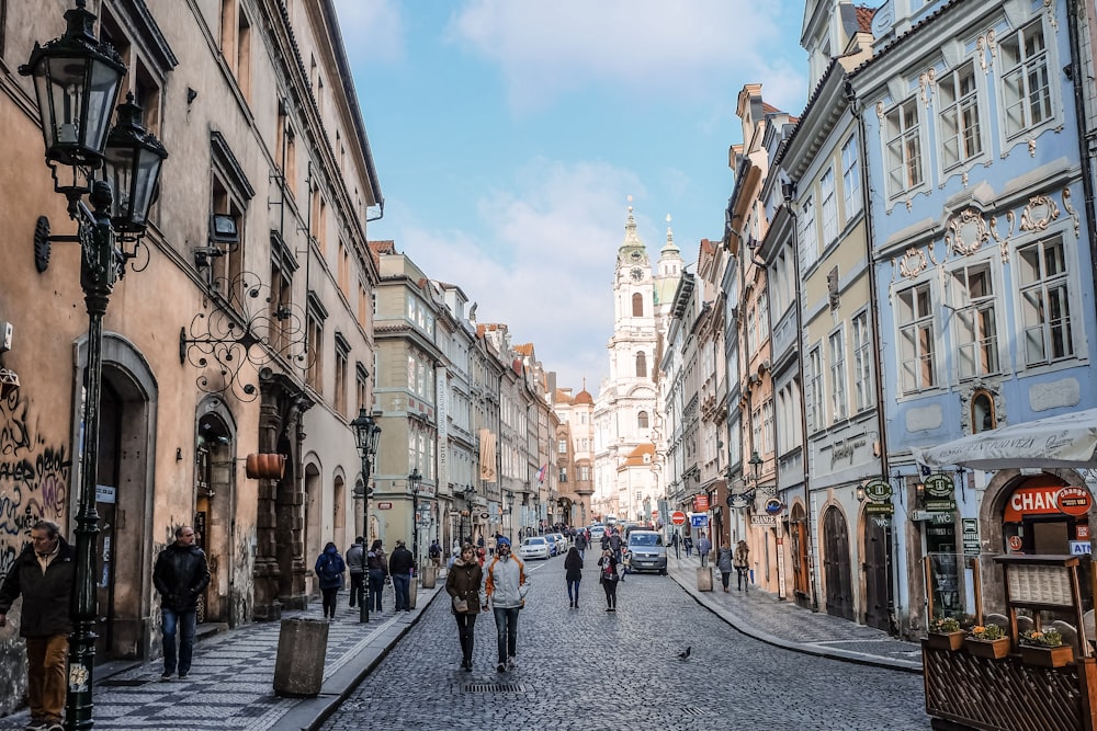 persone che camminano per strada tra gli edifici durante il giorno