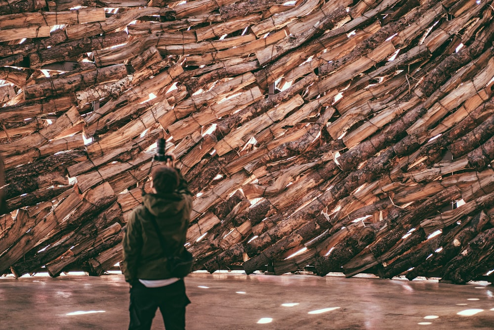 man in brown jacket standing in front of brown wall