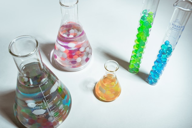 Laboratory glassware with colorful liquids and beads, representing experimentation in quantum
