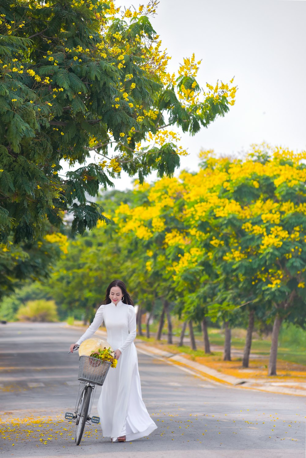 Mujer en vestido blanco caminando por el camino durante el día