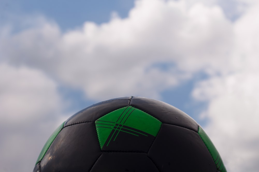 green and black soccer ball under blue sky