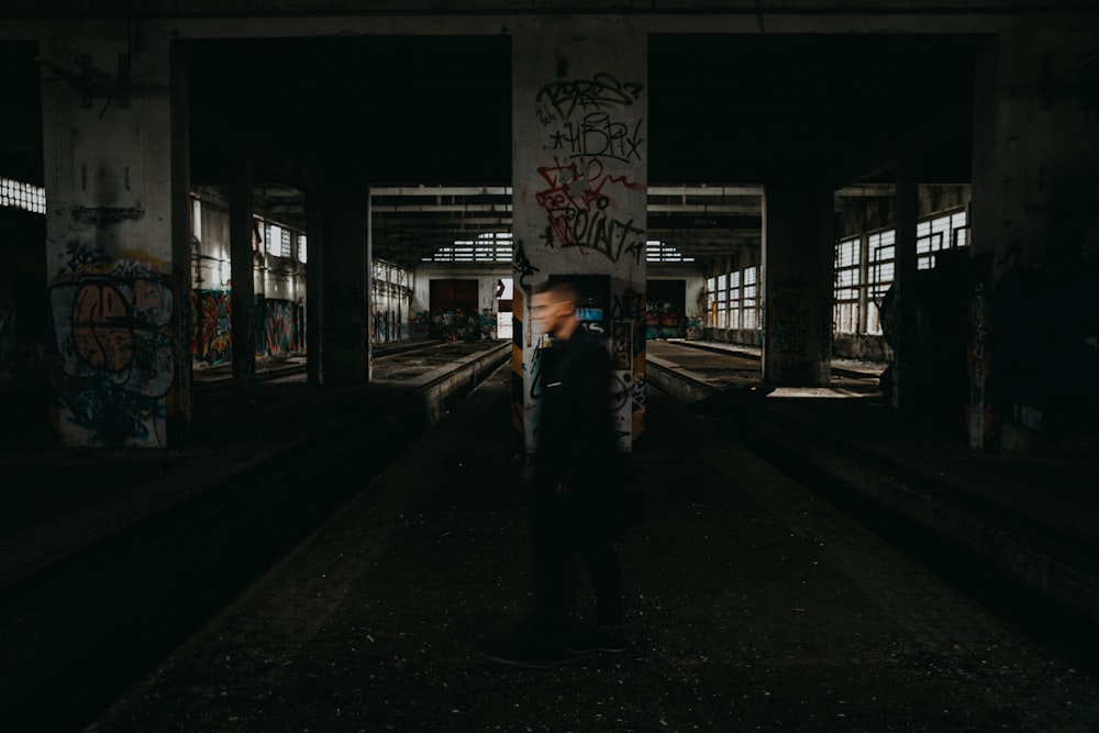 man in black jacket standing on sidewalk during night time