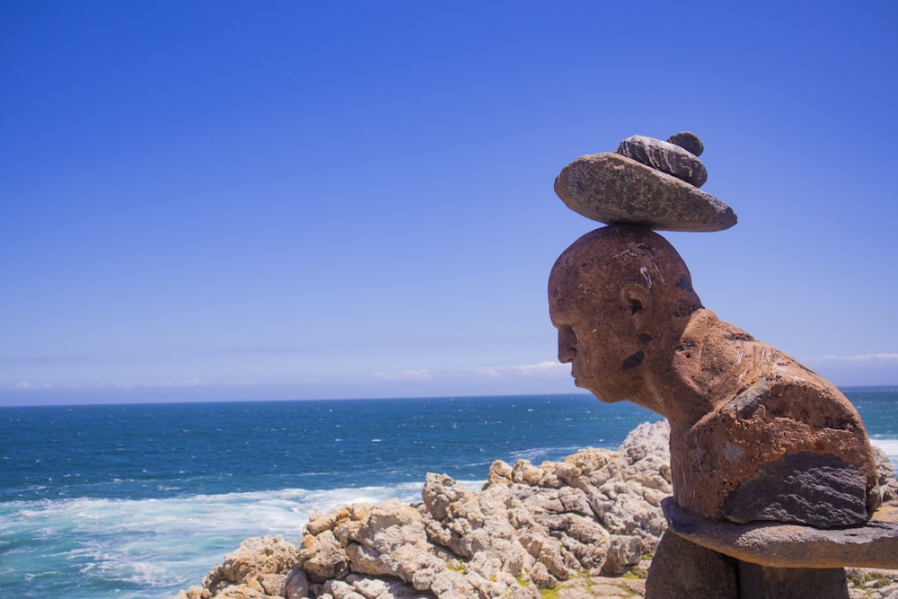 brown rock formation near body of water during daytime