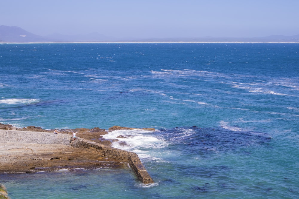 brown rock formation on sea during daytime