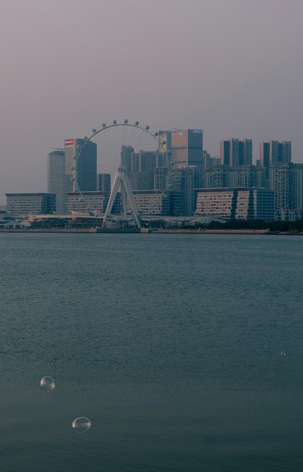 white ferris wheel near city buildings during daytime