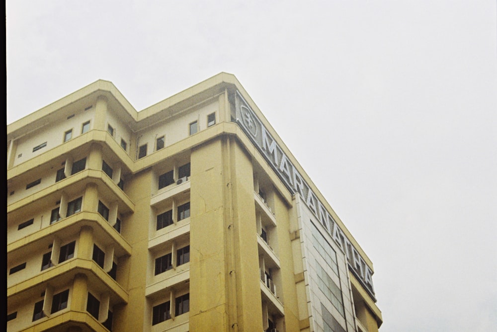 edificio in cemento marrone sotto il cielo bianco durante il giorno