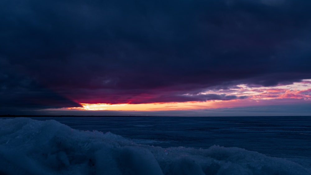 snow covered field during sunset