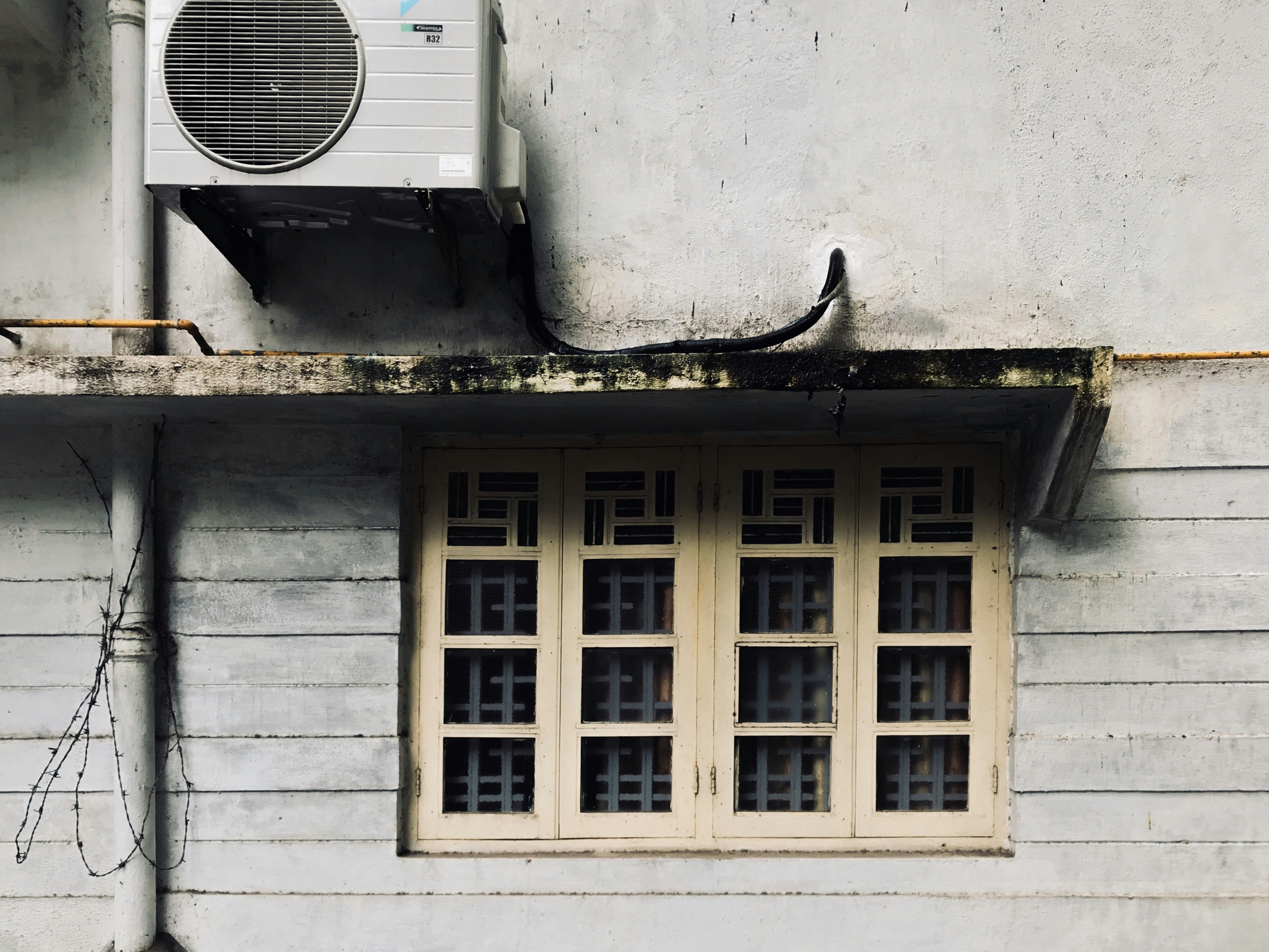 condizionatore d'aria a finestra bianca su parete di cemento bianco