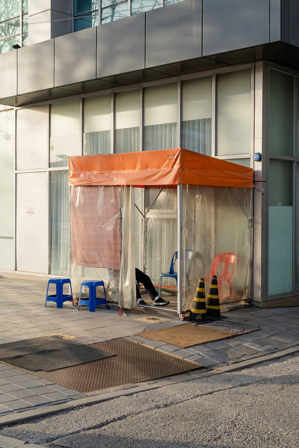 blue and orange plastic chairs beside white wall