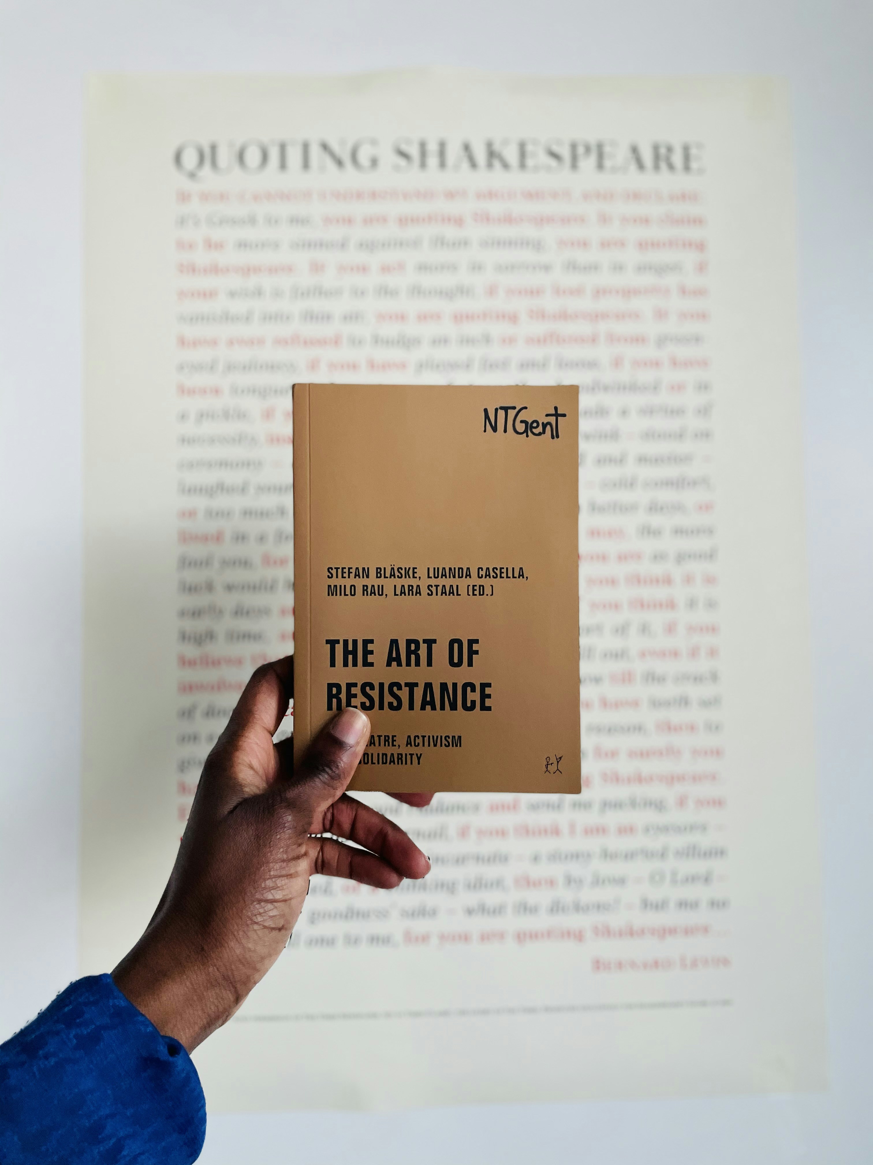 茶色と白の本のページを持っている人