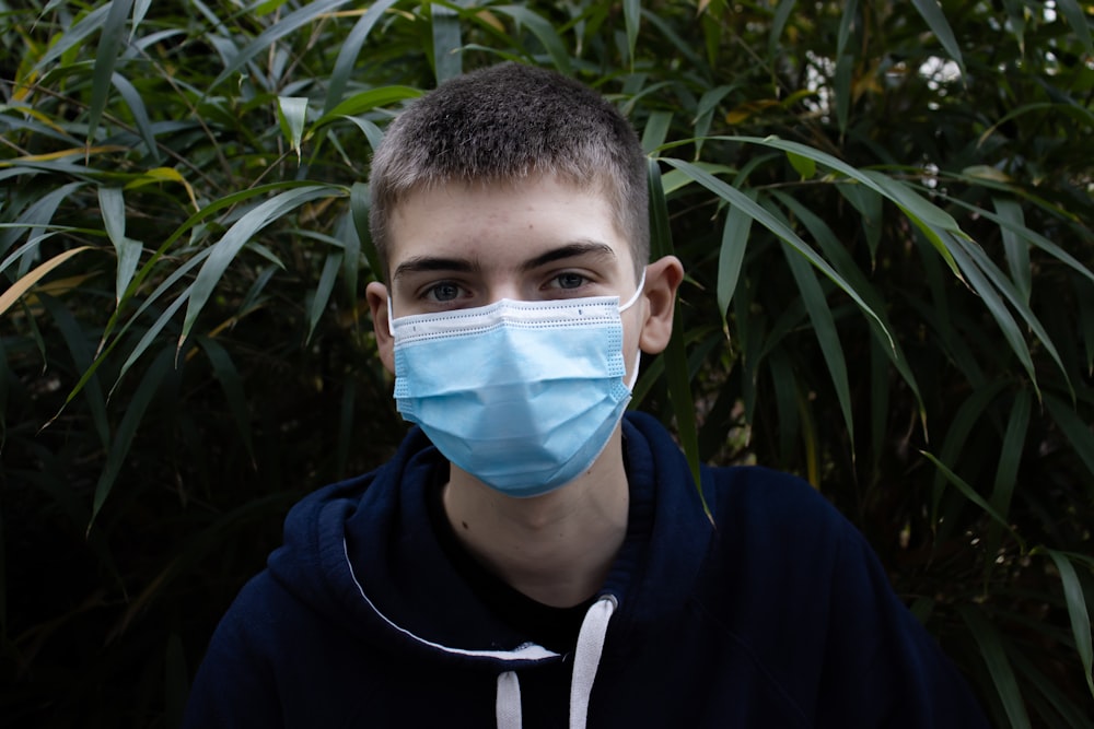 boy in blue and white nike hoodie with blue face mask