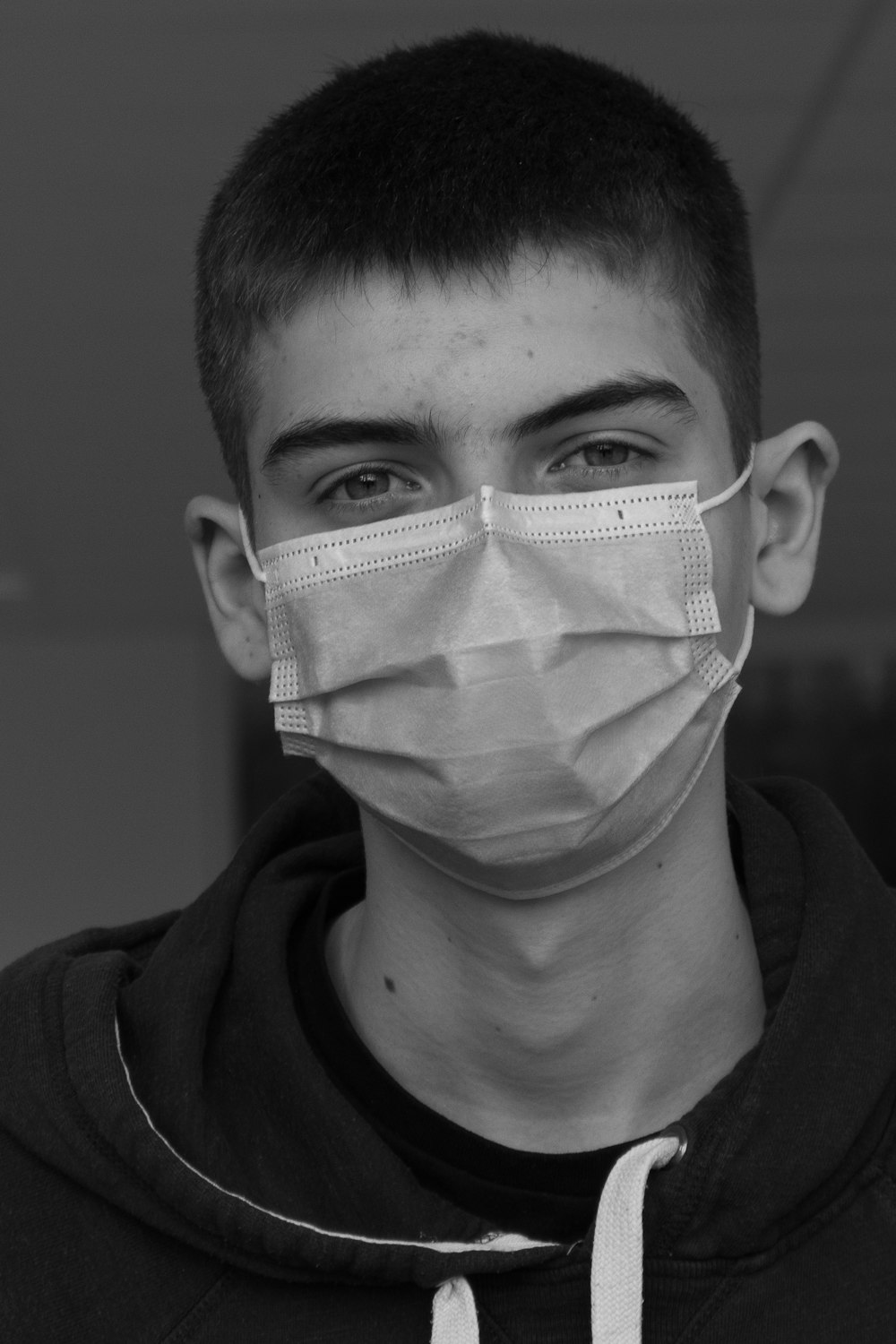 grayscale photo of man with white face mask