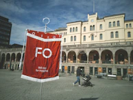 A small flax banner attached to a storefront window, catching the eye of passersby.