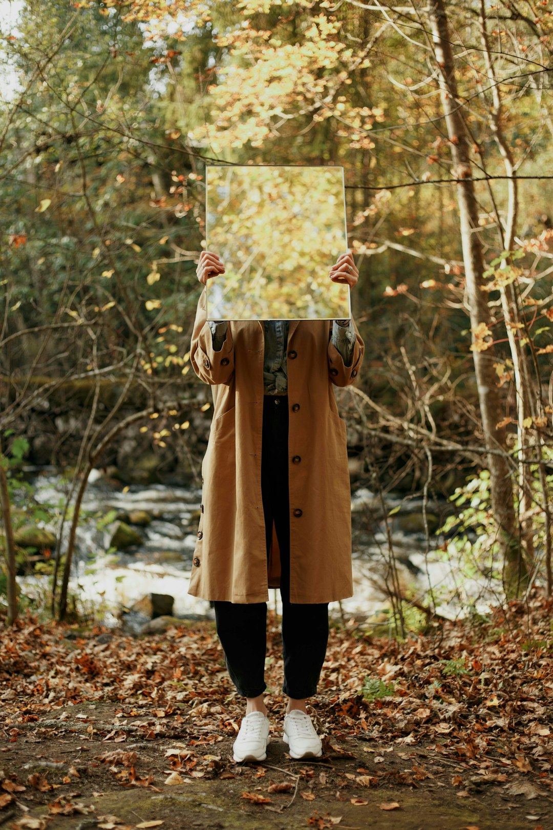 woman in brown coat holding floral frame
