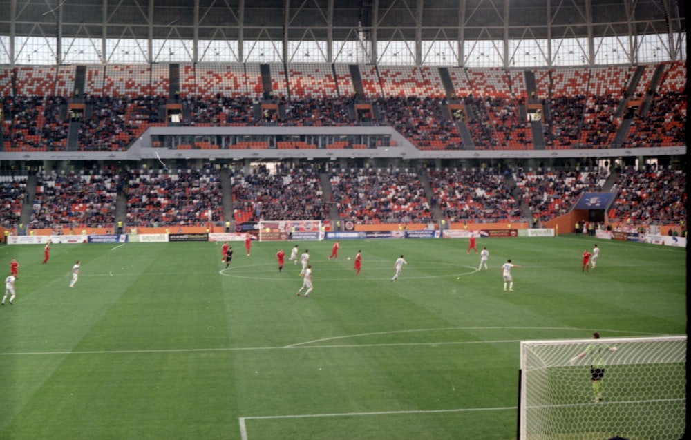 people playing soccer on field during daytime