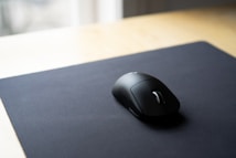 black cordless computer mouse on black surface