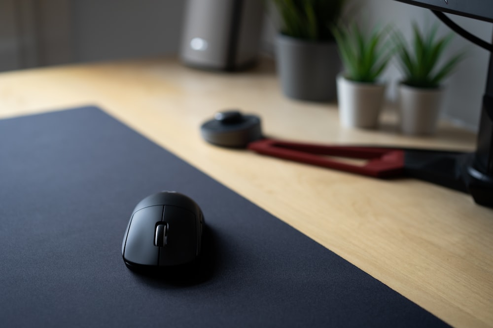 black and gray cordless computer mouse on blue mouse pad