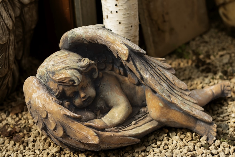 brown wooden angel figurine on brown soil