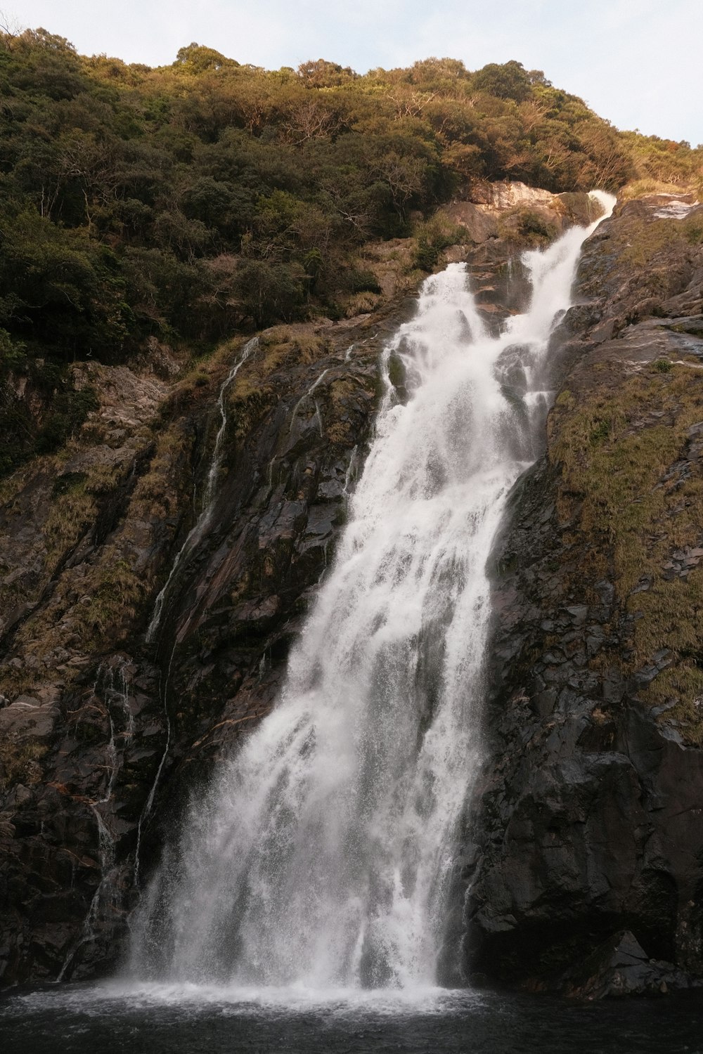 waterfalls on brown rocky mountain during daytime