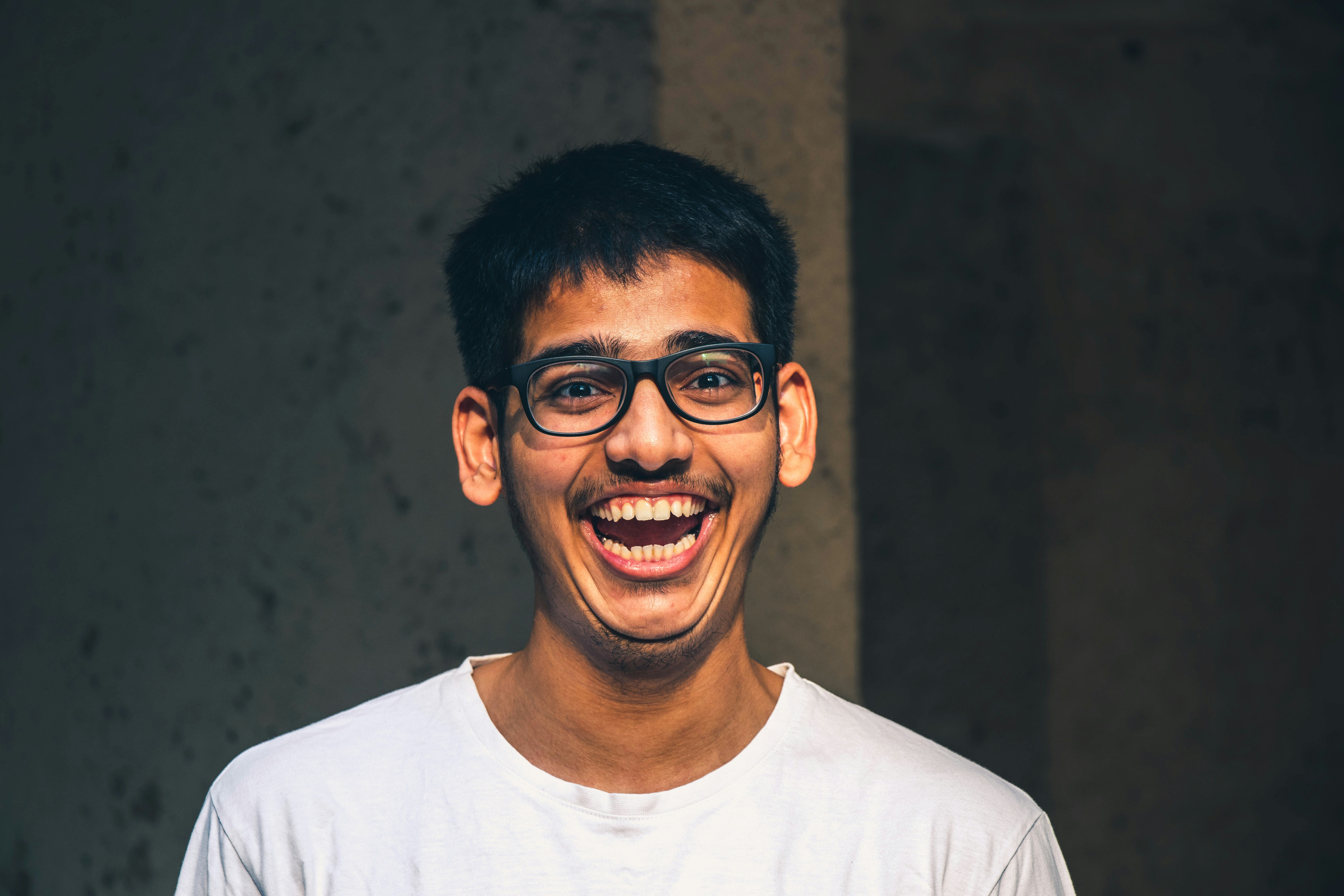 man in white crew neck shirt wearing black framed eyeglasses