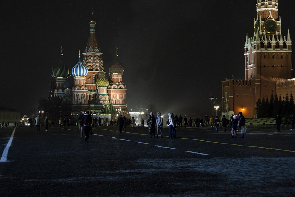 people walking on street near brown concrete building during nighttime