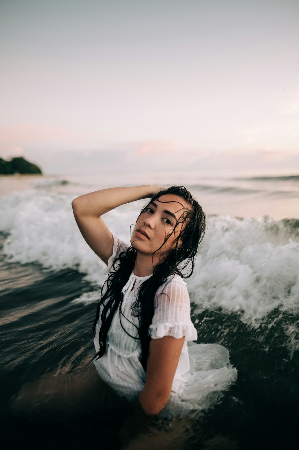 woman in white sleeveless dress standing on seashore during daytime