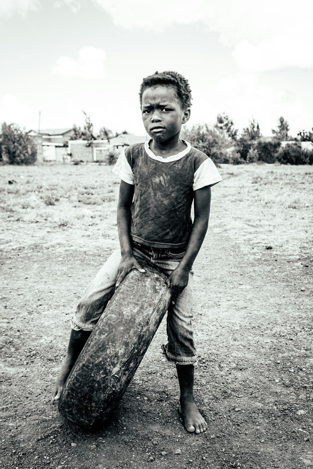 boy in gray crew neck t-shirt and gray denim jeans sitting on brown log during