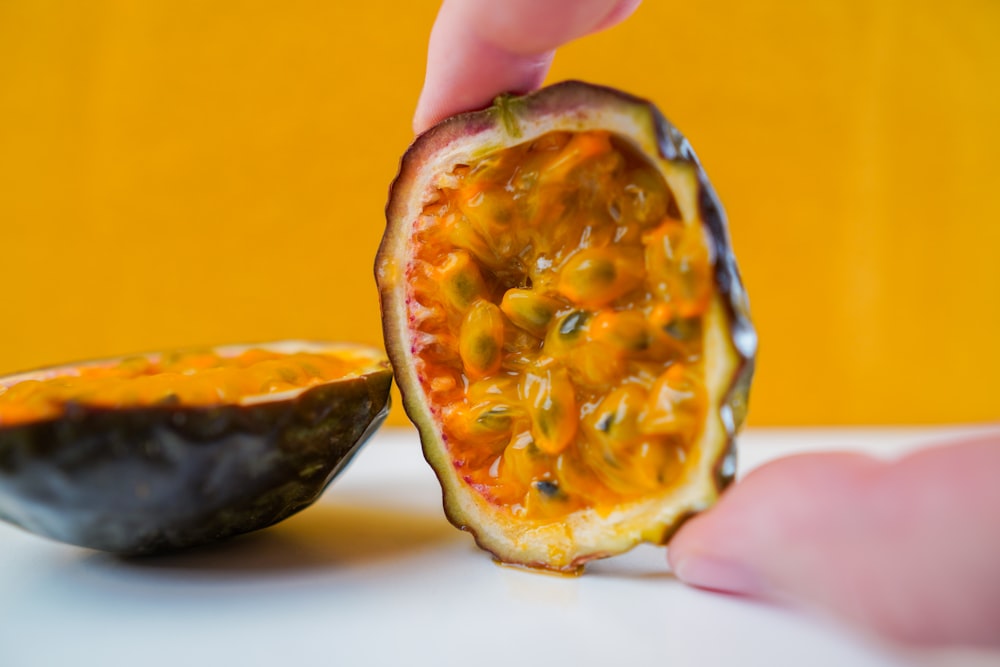 personne tenant des tranches de fruits oranges