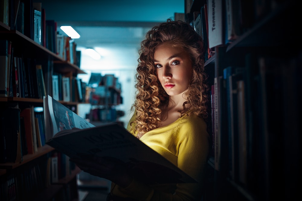 girl in yellow shirt holding black textile