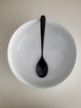 stainless steel spoon on white ceramic plate