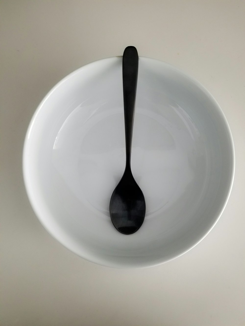 cuchara de acero inoxidable sobre plato de cerámica blanca