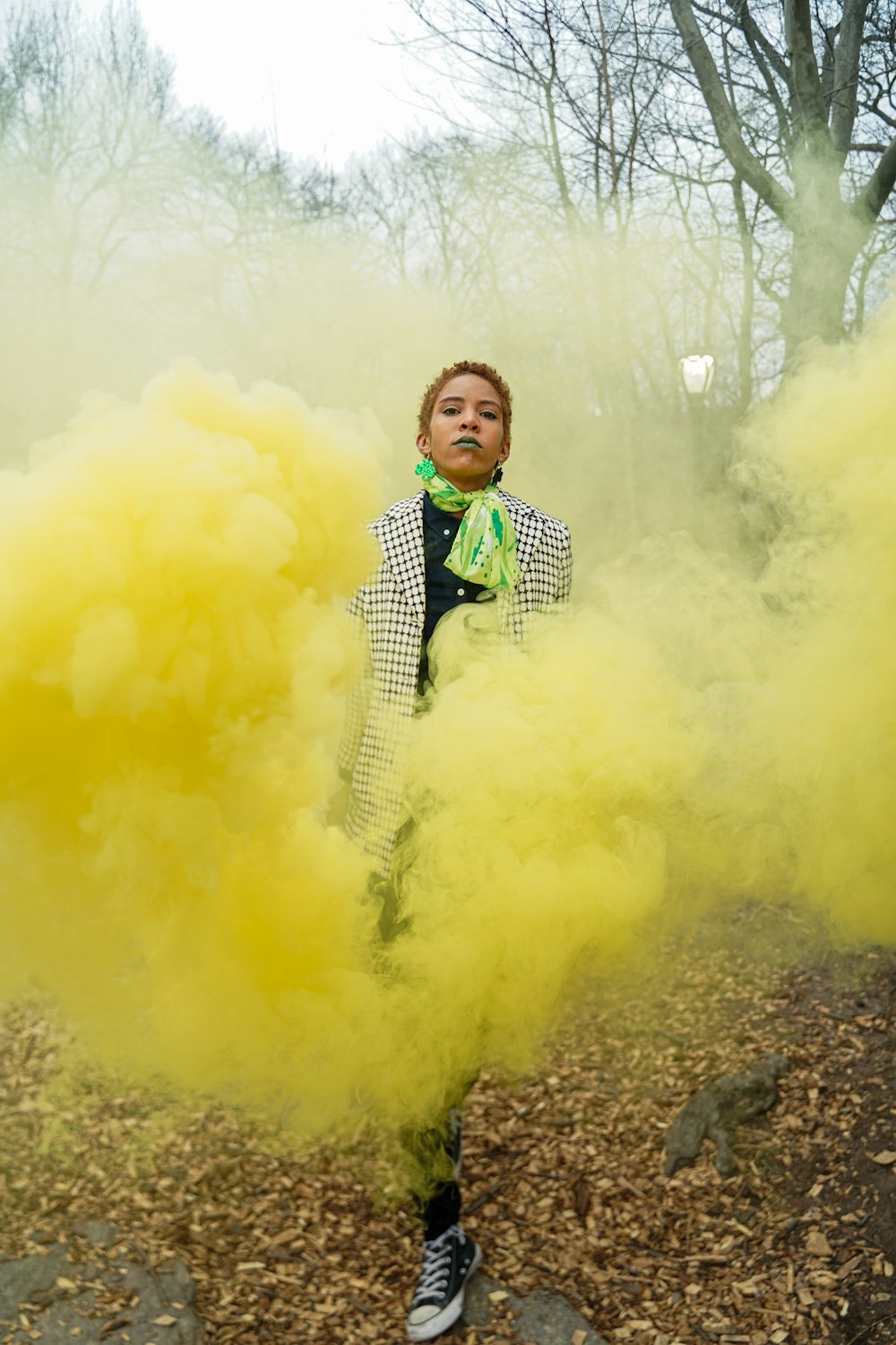 boy in black and white suit standing on ground with yellow smoke