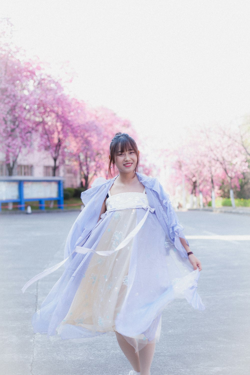 woman in white dress standing on road during daytime