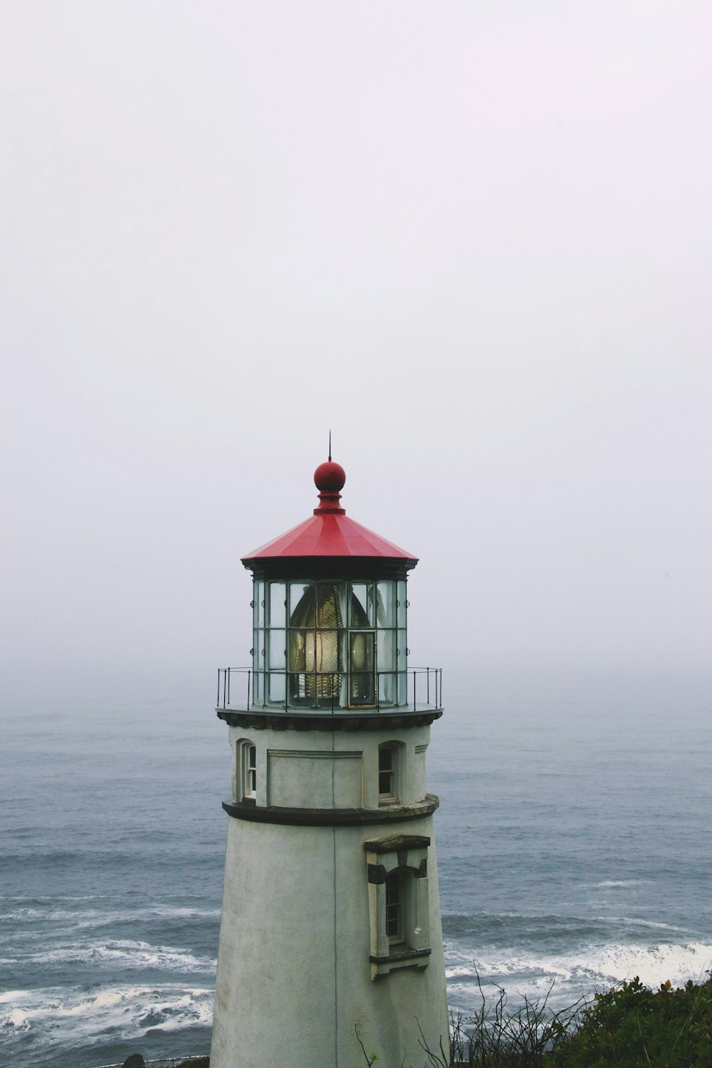 white and red lighthouse near body of water during daytime