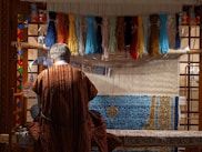 man in red robe standing in front of blue and yellow wall