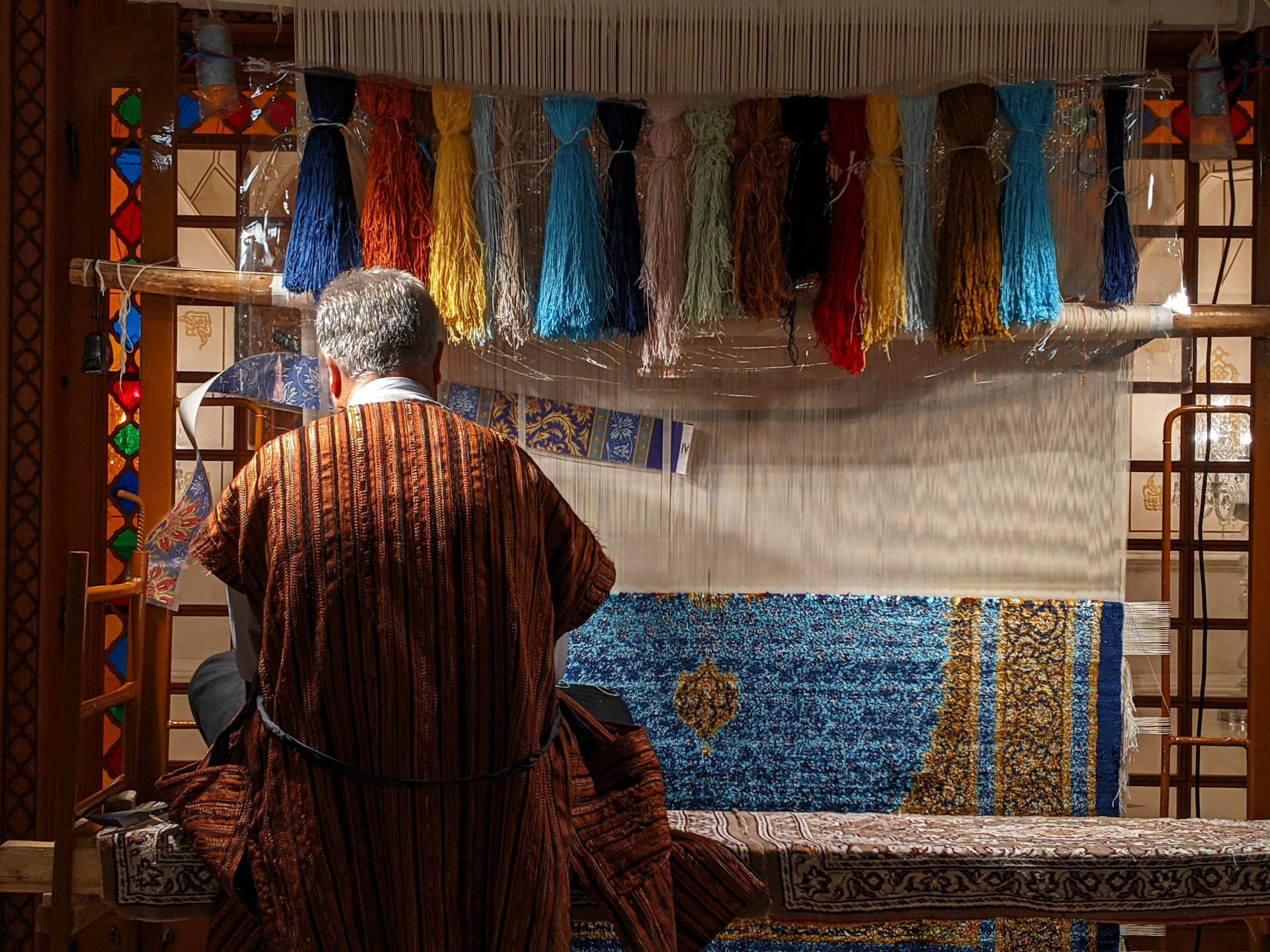 man in red robe standing in front of blue and yellow wall