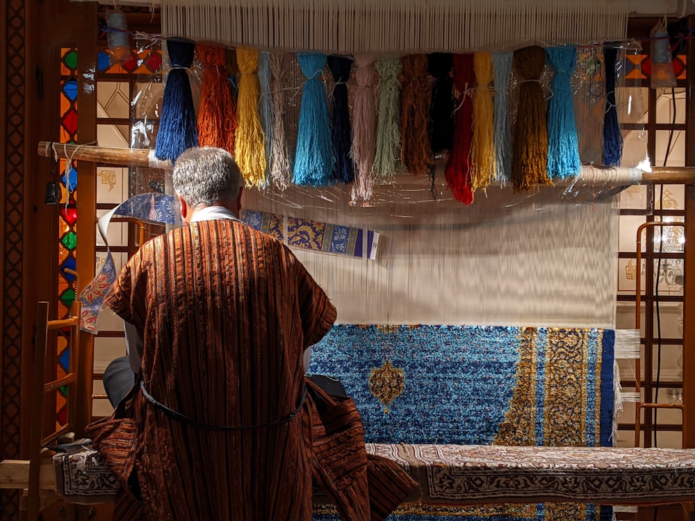 man in red robe standing in front of blue and yellow wall